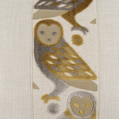 Pillow featuring beige, gray & gold owl motifs on a tapestry-style woven fabric.