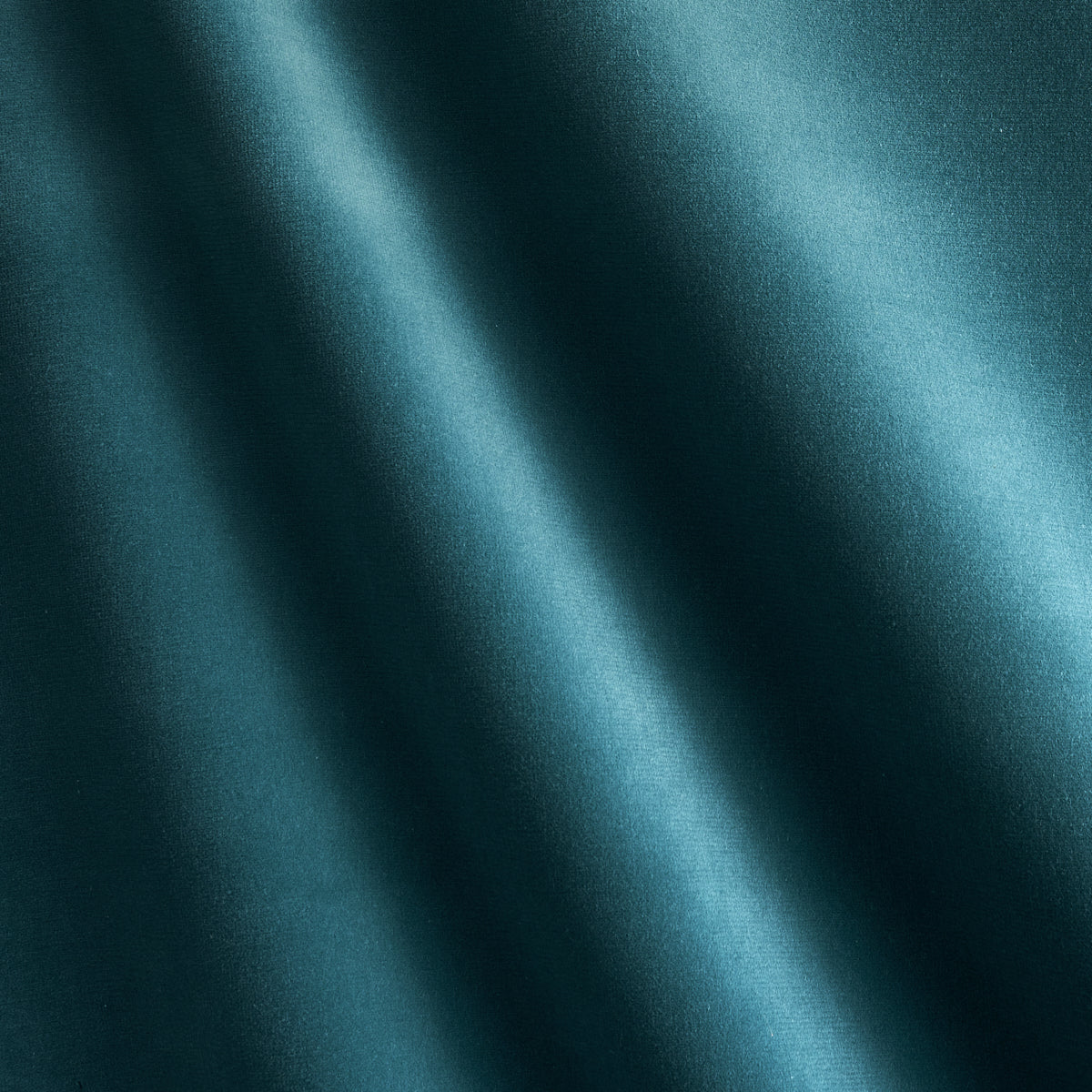 Teal velvet fabric with diagonal folds and subtle glossy sheen.