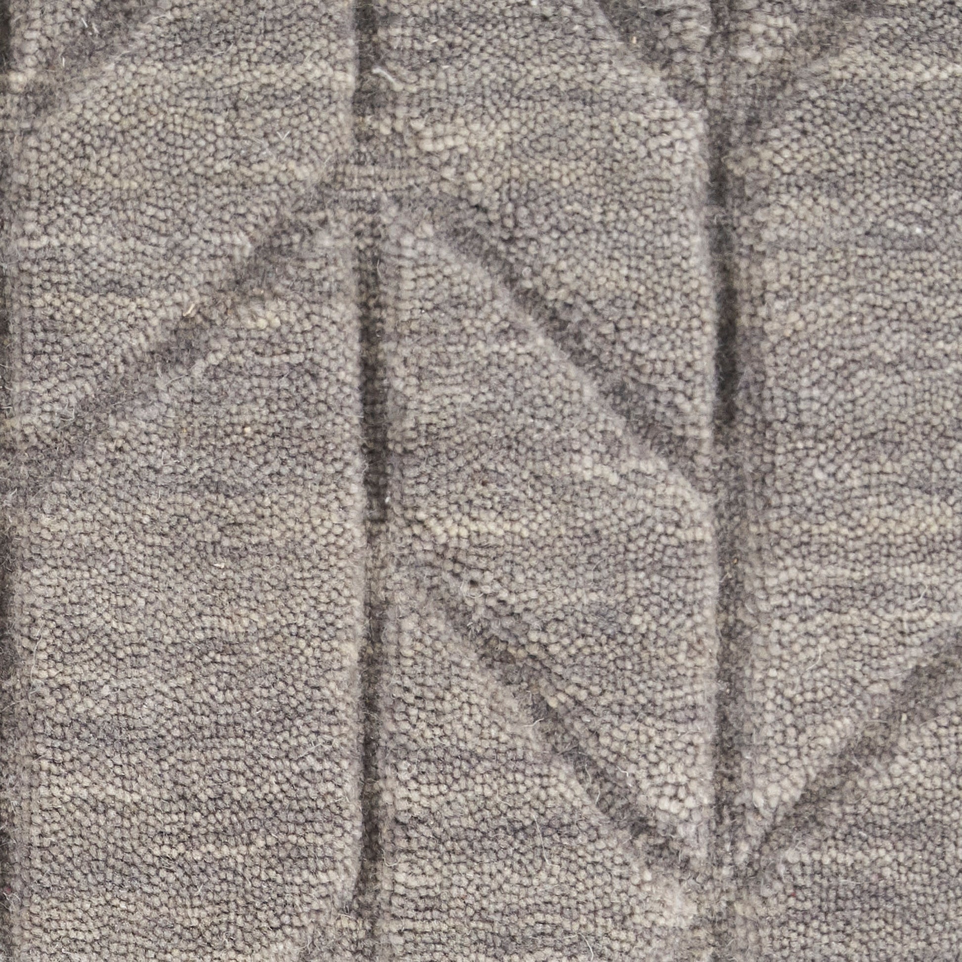 Gray boucle fabric with geometric triangular quilting; plush textured rug.