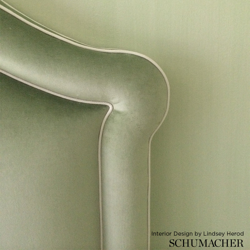 Close-up of sage green velvet upholstery fabric with a smooth nap.