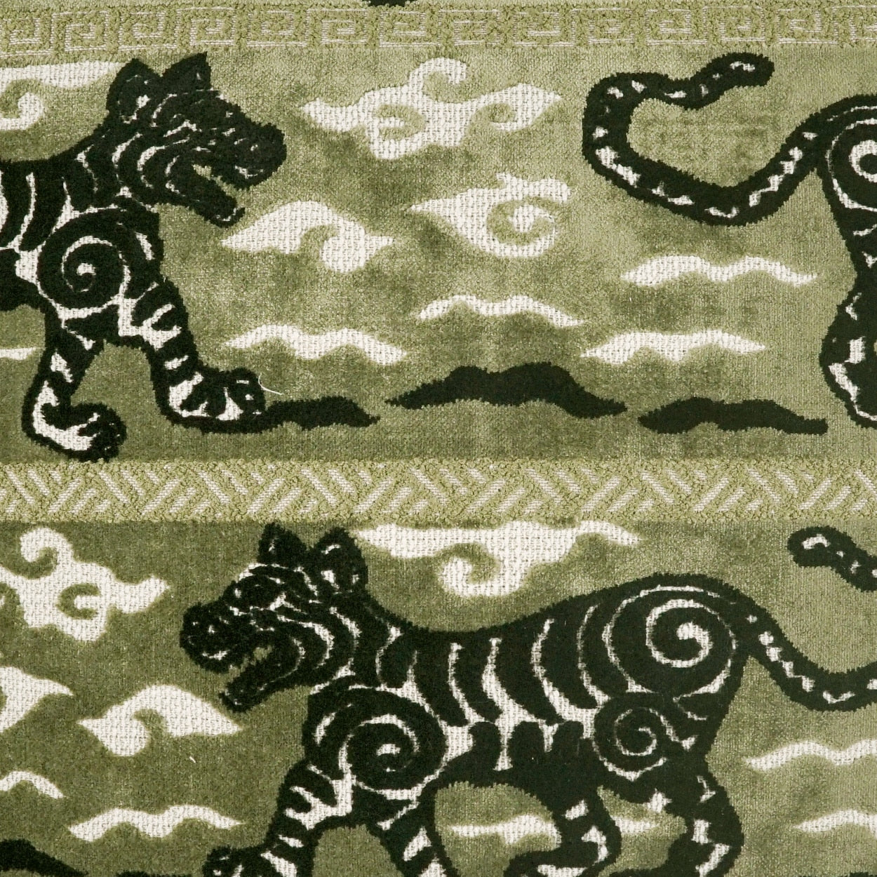 Olive-green fabric with black tiger silhouettes, white cloud motifs, and a geometric border for home decor.
