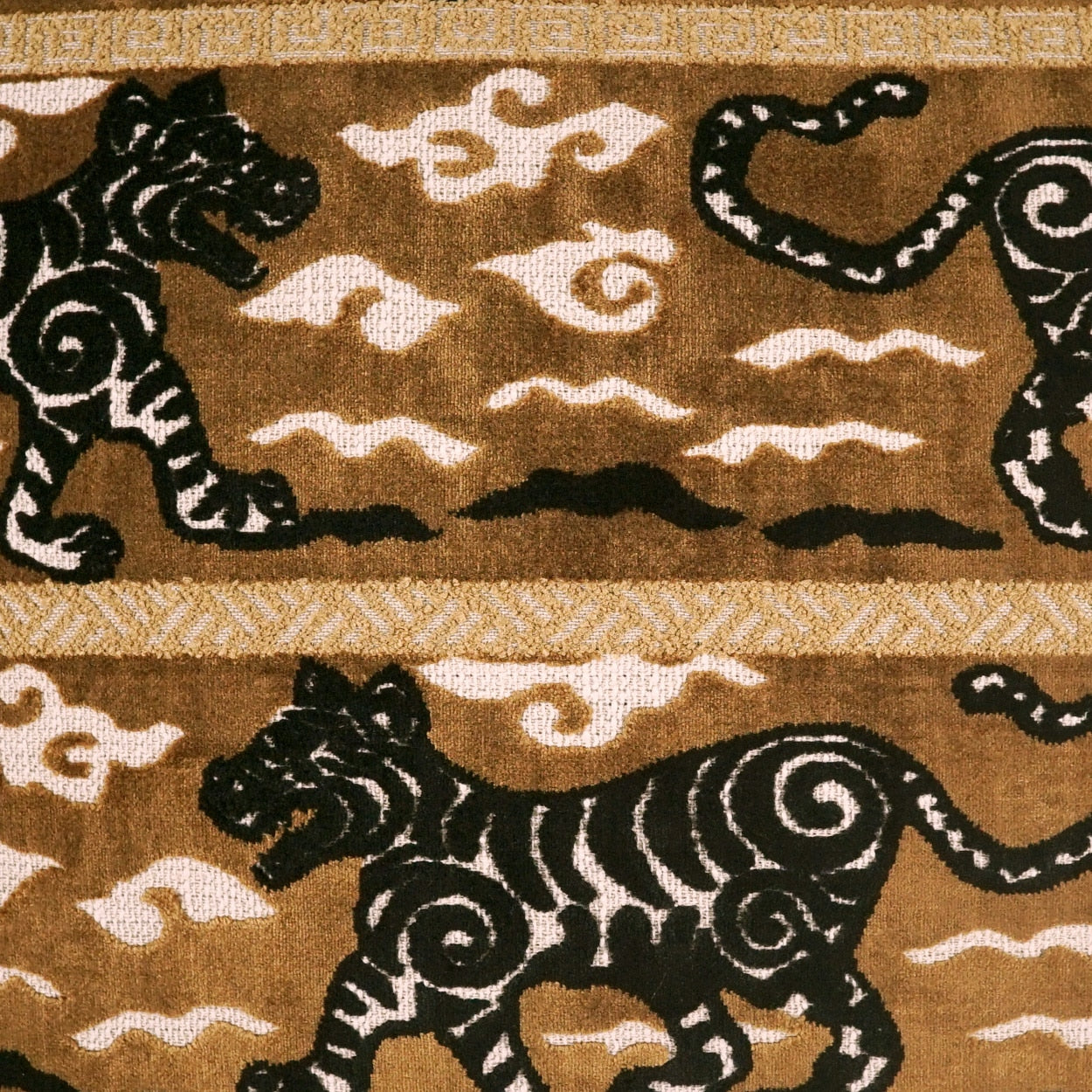 Brown fabric with black tiger silhouettes, white swirl patterns, and a beige geometric border.