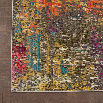 Colorful abstract area rug on dark wood floor; teal, pink, yellow and gray patches, rectangular with a light border.