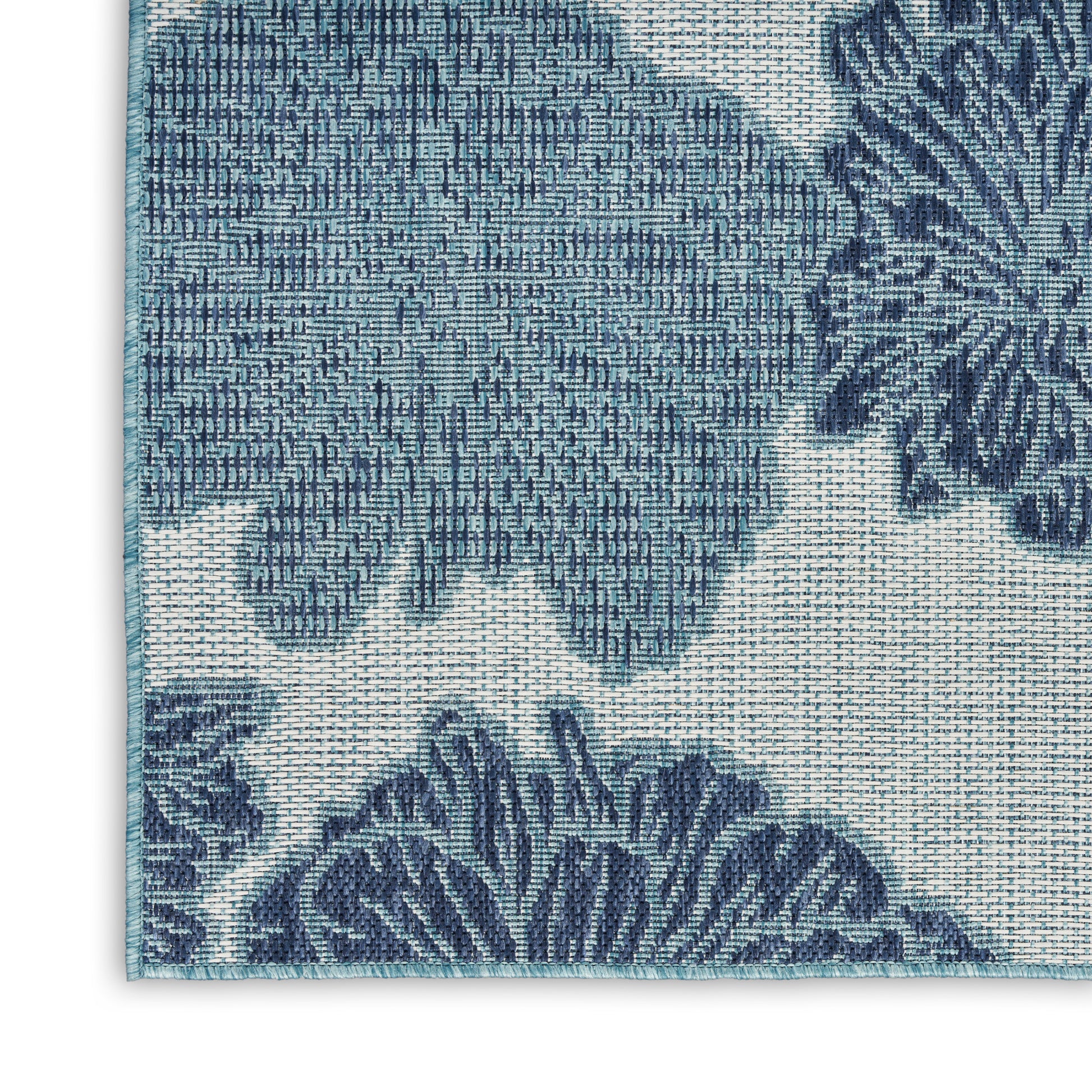 Rectangular blue damask woven rug with navy floral motifs and teal border.