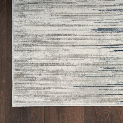Light gray flat-weave rug with subtle blue-gray horizontal brushstroke pattern; rectangular, modern living room decor.