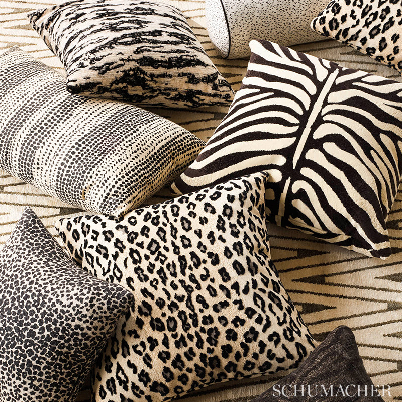 Assorted animal-print throw pillows: zebra, leopard & cheetah patterns in plush beige & black fabrics.