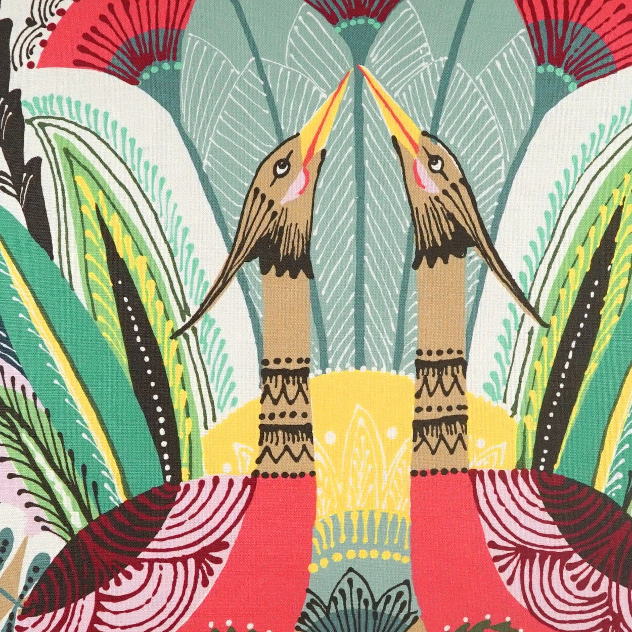 Vibrant fabric print featuring two cranes facing each other among stylized tropical leaves in teal, green, yellow and red.