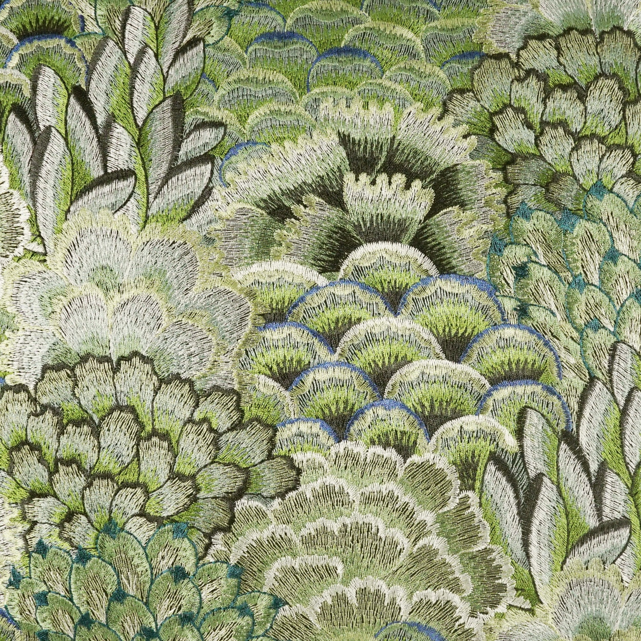 Close-up of green embroidered fabric with overlapping scallop-scale pattern in lime, olive, cream and blue accents.