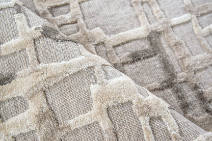 Beige woven textile rug with plush raised geometric grid pattern in cream and taupe tones.