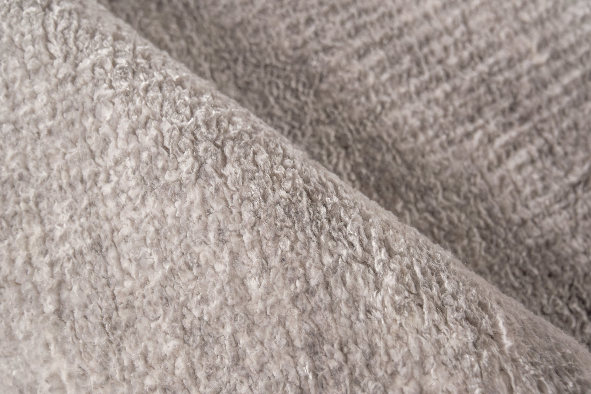 Beige plush rug close-up showing soft fluffy pile.