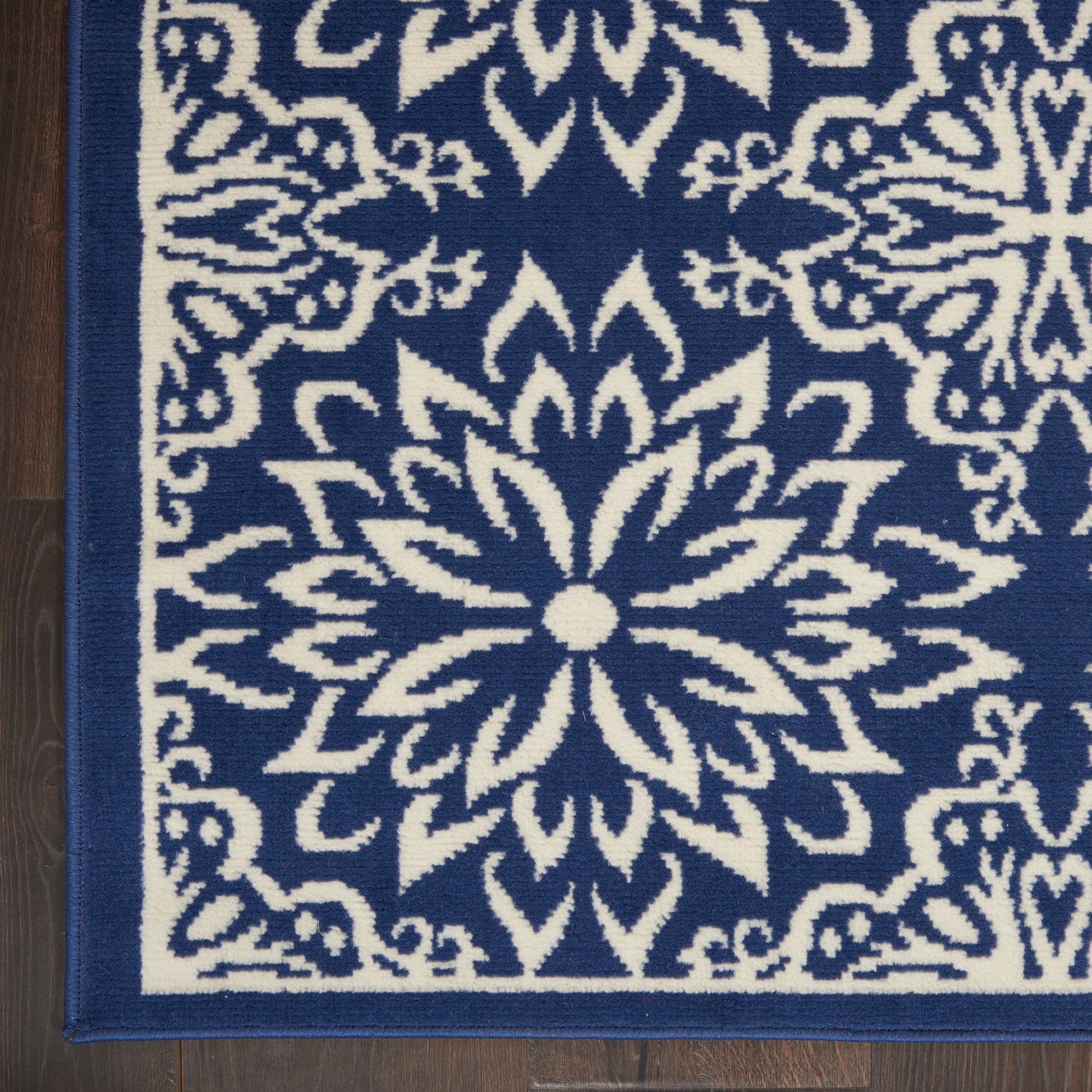 Navy blue rug with white floral mandala medallion pattern and border; square decorative floor rug.