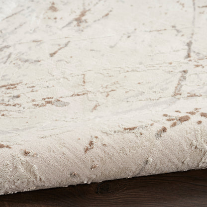 Cream-beige plush area rug with subtle brown abstract pattern on dark wood floor.