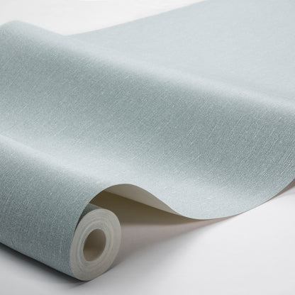 Light blue linen-textured wallpaper roll with subtle fabric grain; curled edge exposes inner core.