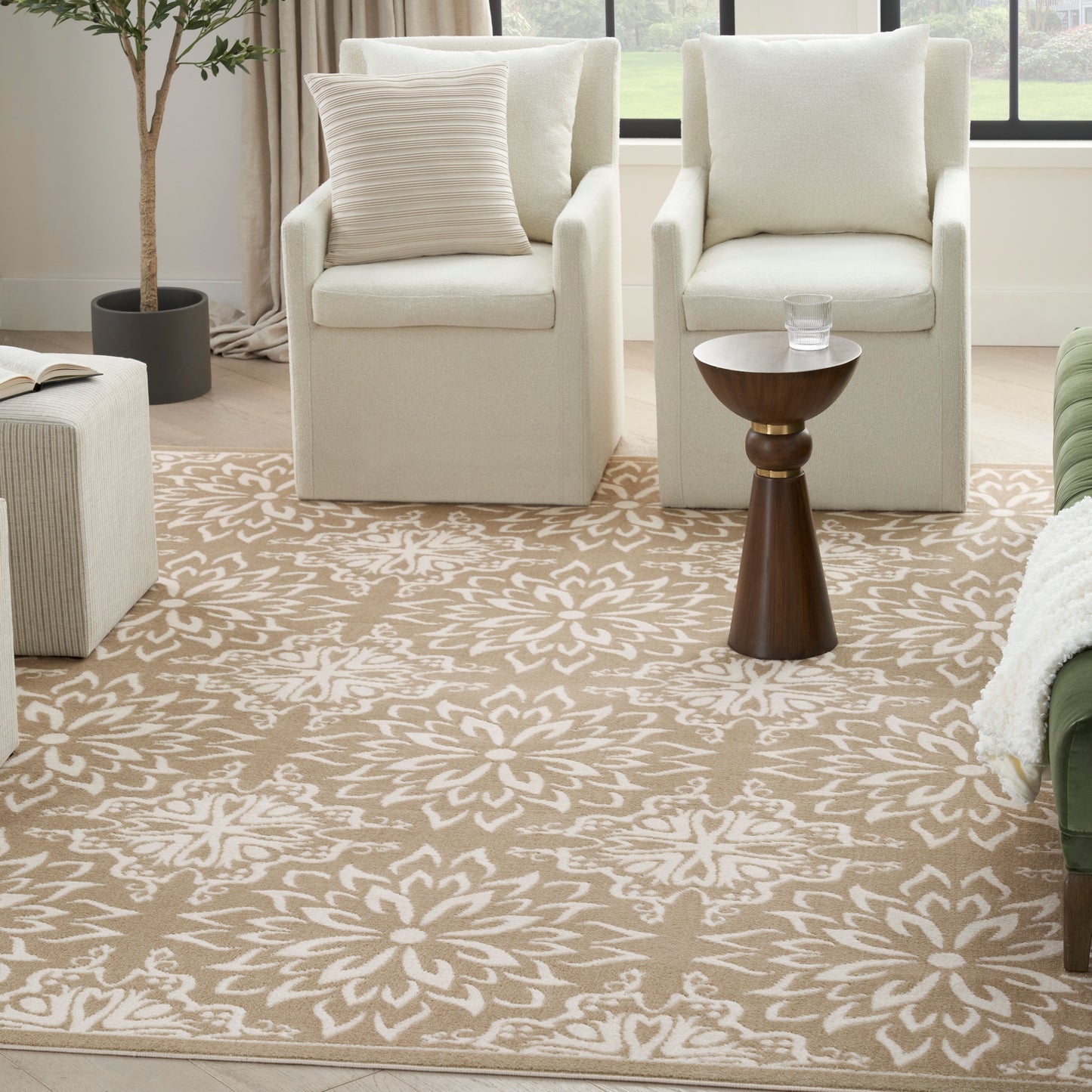 Neutral living room with cream armchairs, a tan floral rug, and a dark wood side table.