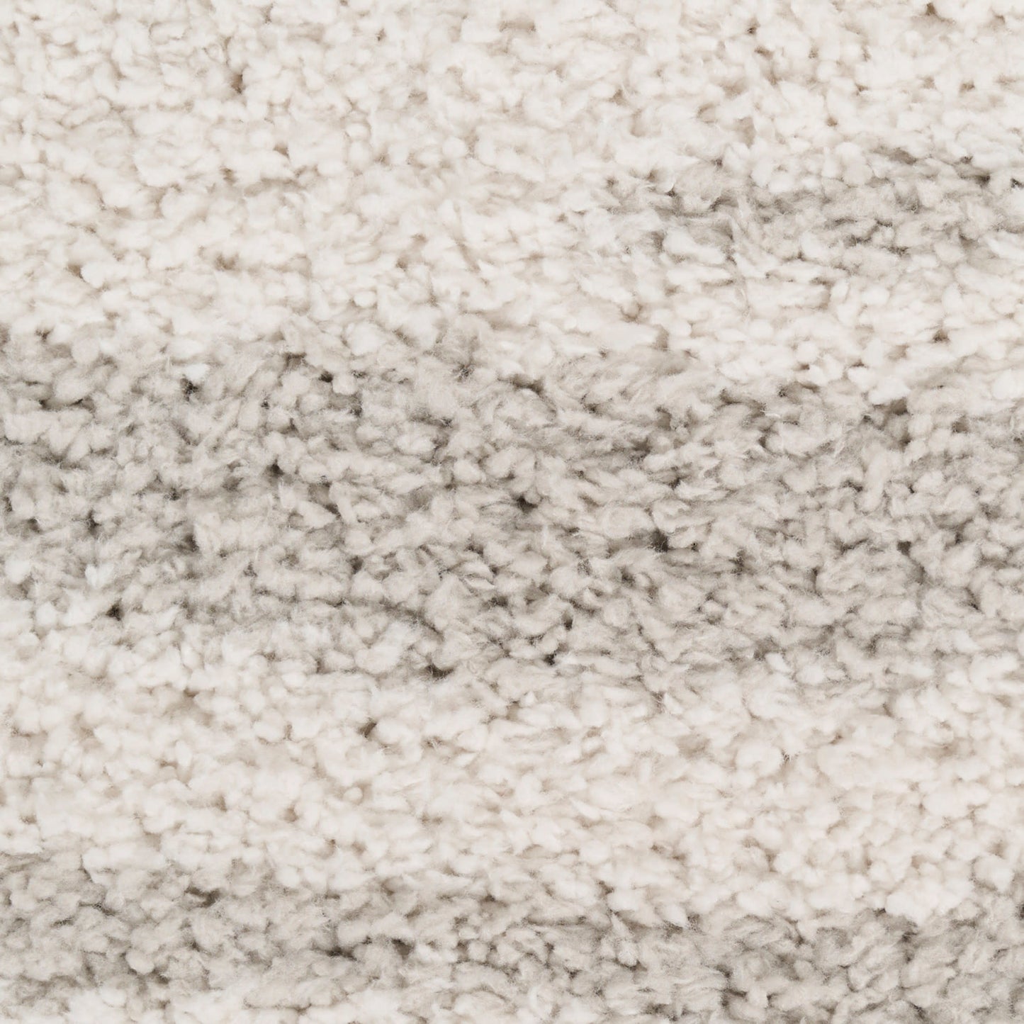 Cream shag rug with thick, plush pile and subtle tonal shading; perfect for cozy living room floors.