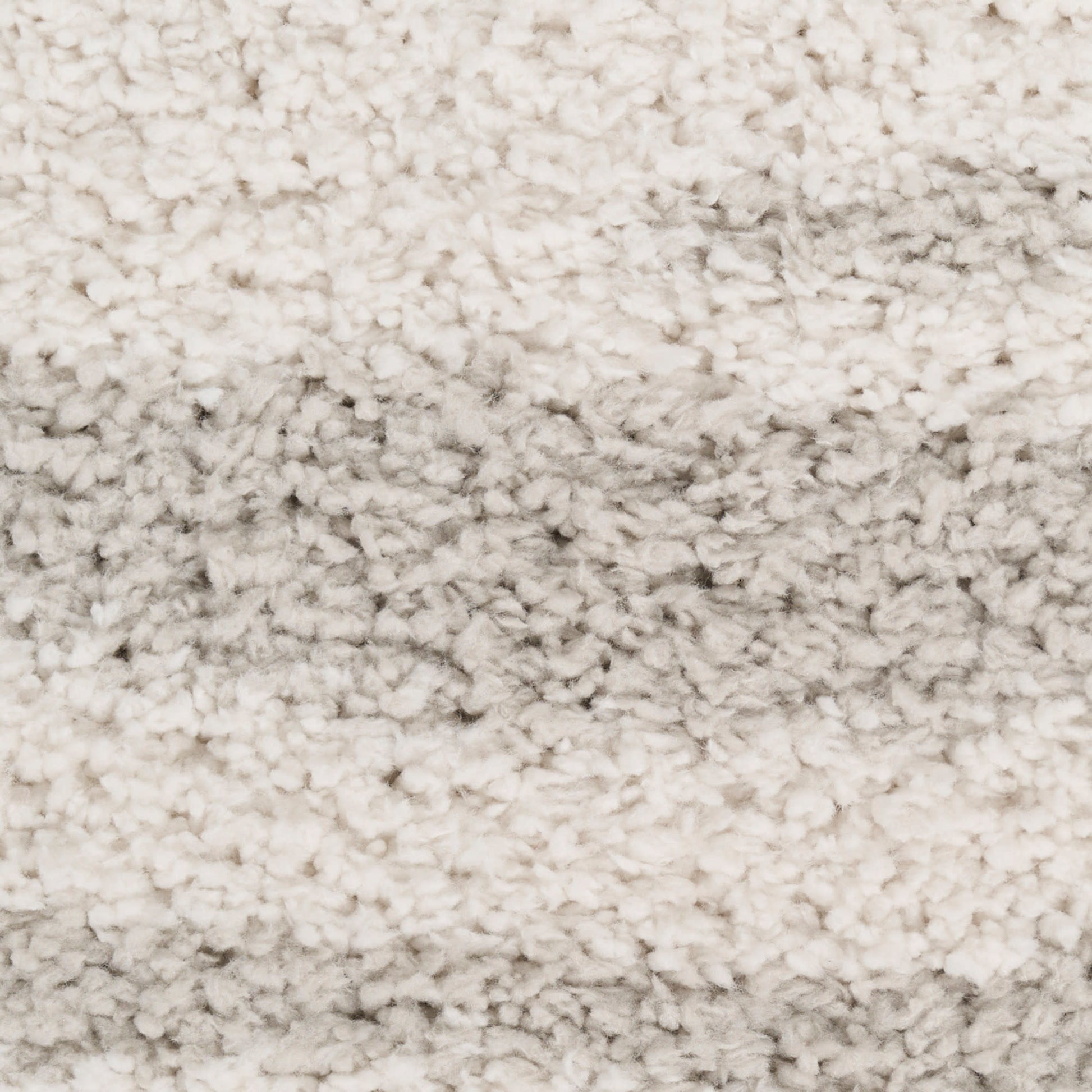 Cream shag rug with thick, plush pile and subtle tonal shading; perfect for cozy living room floors.