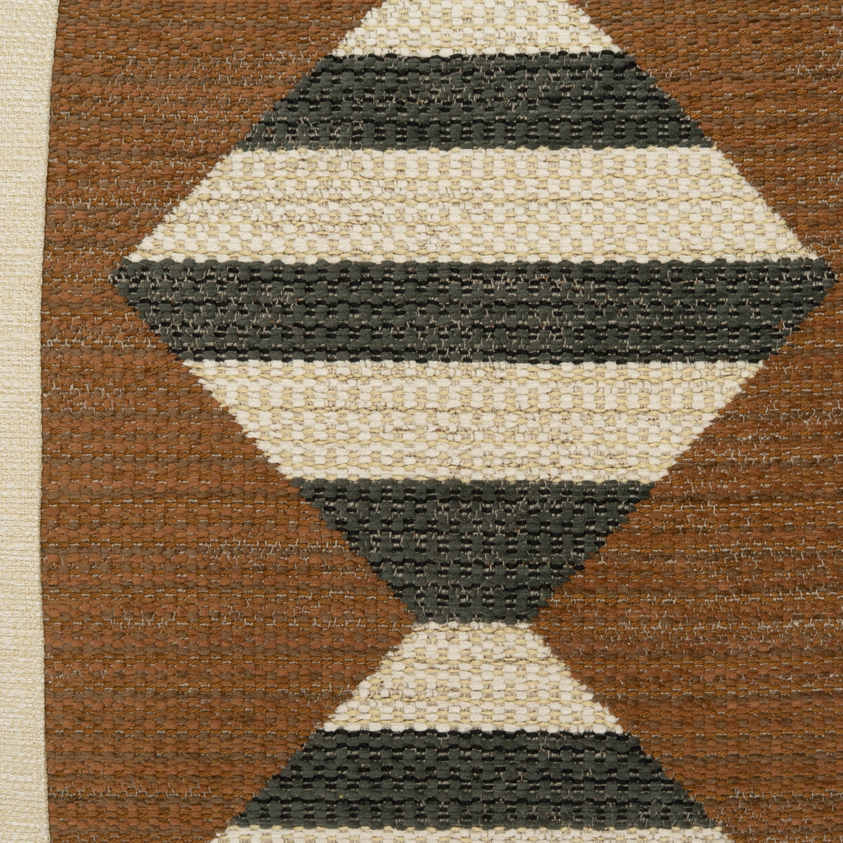 Square 24x24 Tarantelli decorative pillow featuring a bold geometric woven pattern of repeating diamond and hourglass shapes in charcoal, ivory, and warm brown tones, with a contrasting neutral border and coordinating fabric on both sides.