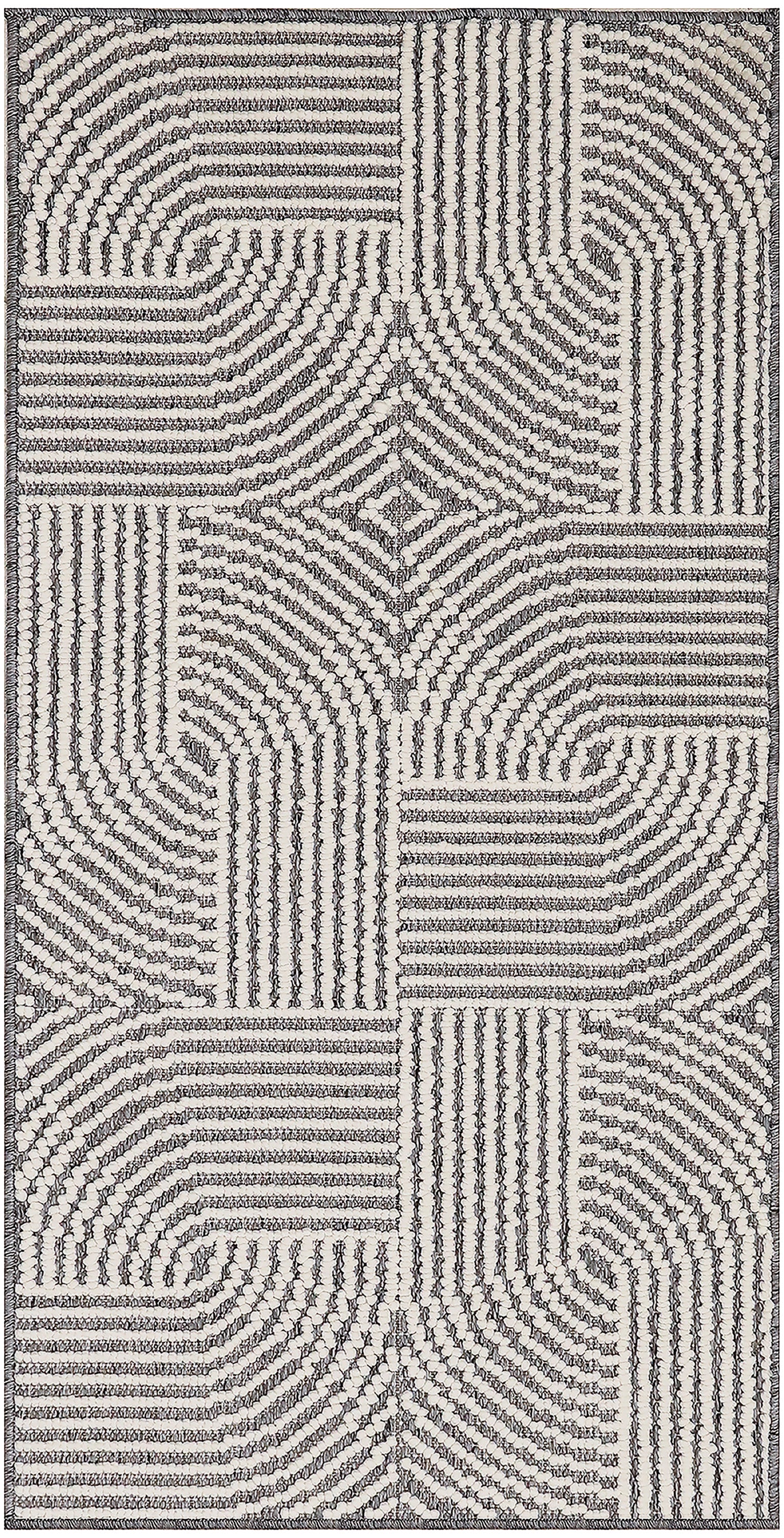 Cream and charcoal looped-pile rug with patchwork panels of striped, curved and grid-like patterns.