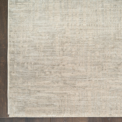 Neutral beige rectangular area rug with subtle textured pattern on dark wood floor.