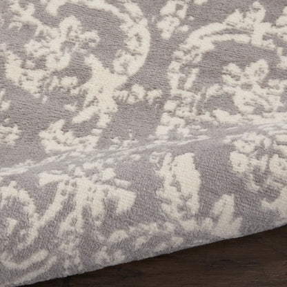 Taupe rug with white damask floral pattern, plush textured weave, ideal for living room or bedroom.