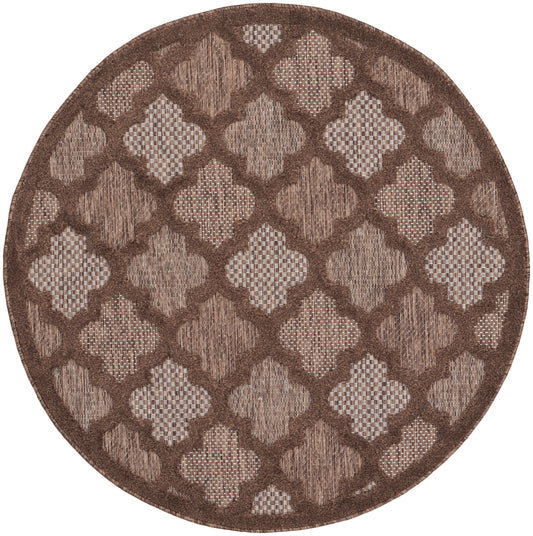 Round brown rug with repeating beige quatrefoil lattice pattern and textured weave, dark border.