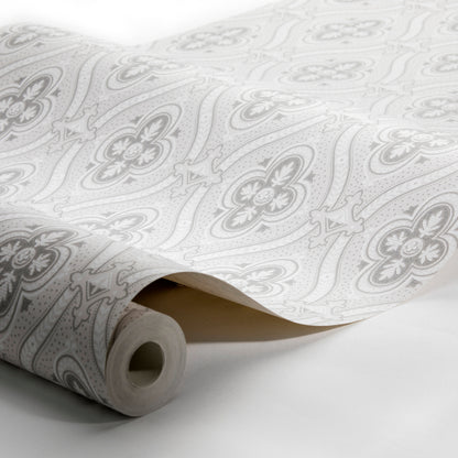 Rolled wallpaper with light gray floral damask pattern on white, unfurling to show intricate repeating design.