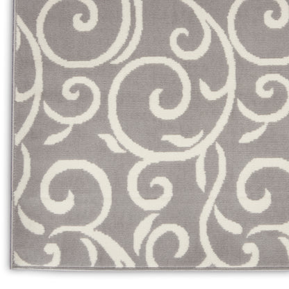 Grey area rug with white swirling scroll pattern, soft textured surface, light border along the edges.