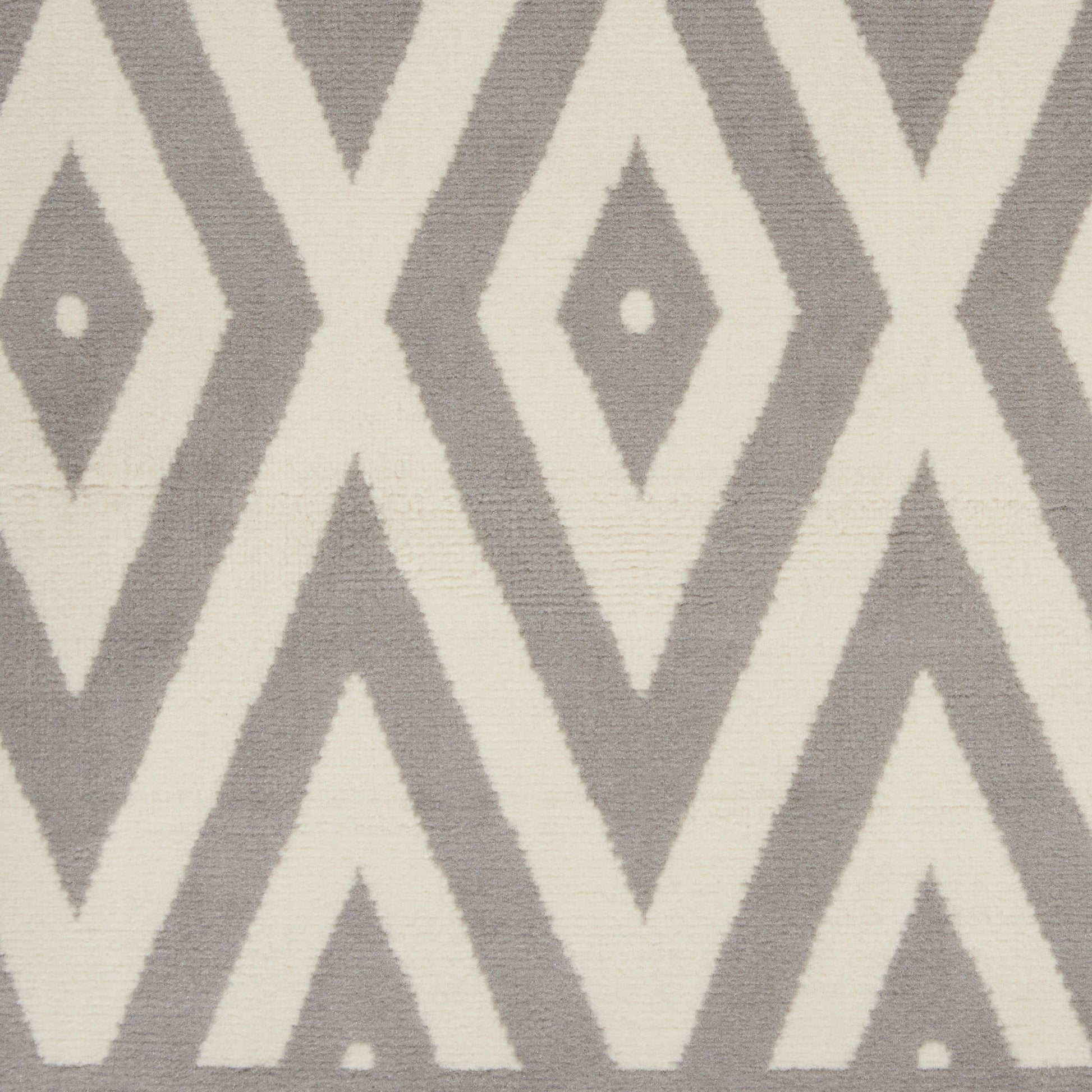 Woven rug in cream and taupe with diamond and chevron geometric pattern; neutral modern decor.