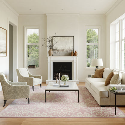 Bright neutral living room with beige sofa, two patterned armchairs, white fireplace, pink rug, glass-top coffee table.