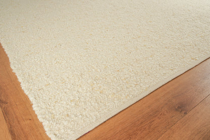 Cream flat-weave indoor area rug on a light brown wood floor.
