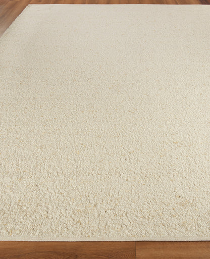 Cream indoor flat-weave rug on warm wood floor in neutral beige tones.