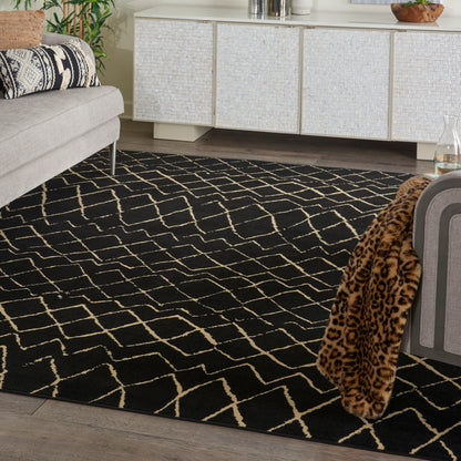 Black area rug with cream geometric lattice pattern in a modern living room with light sofa and leopard throw.