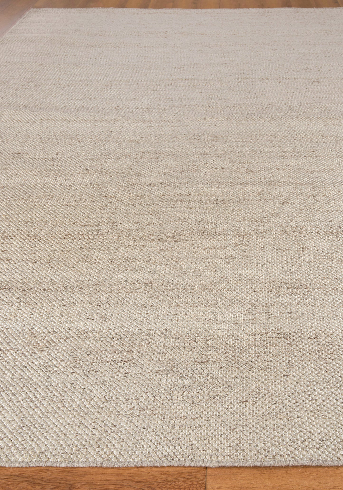 Natural beige jute rug with textured woven fibers on wood floor.