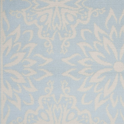Light blue fabric with an intricate white damask floral pattern, classic decorative textile for upholstery.