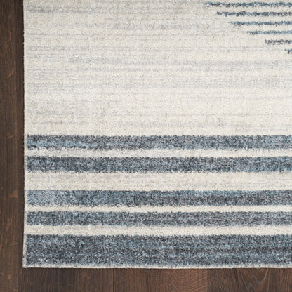 Flat-weave area rug with ivory background and blue horizontal stripes on a dark wooden floor.