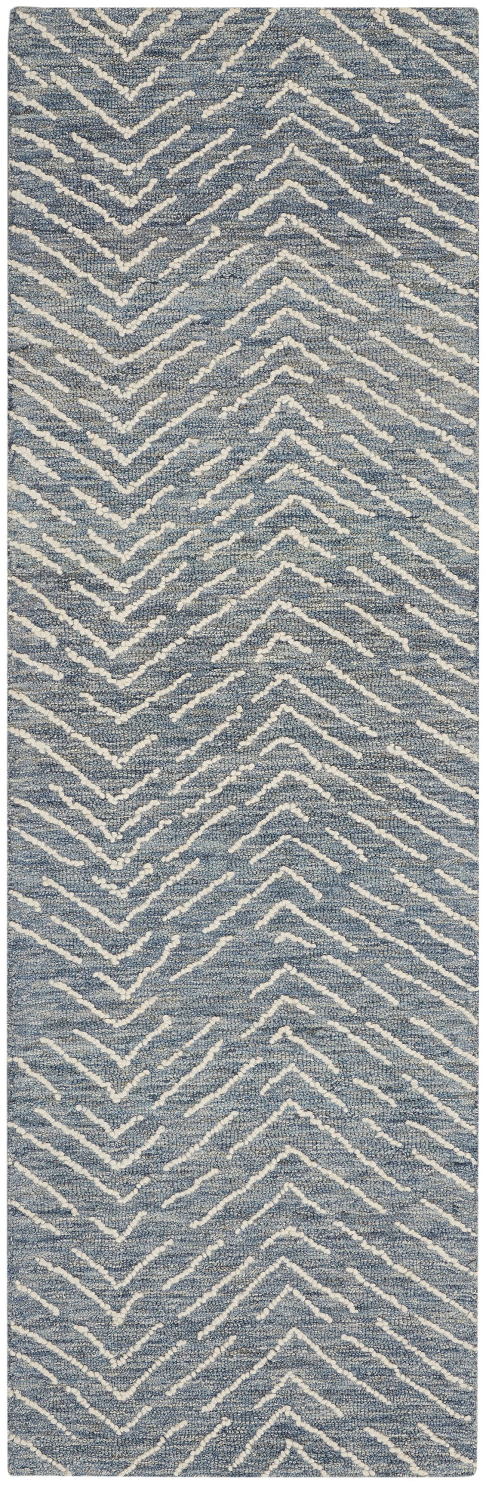 Blue textured rug runner with white chevron zigzag pattern.