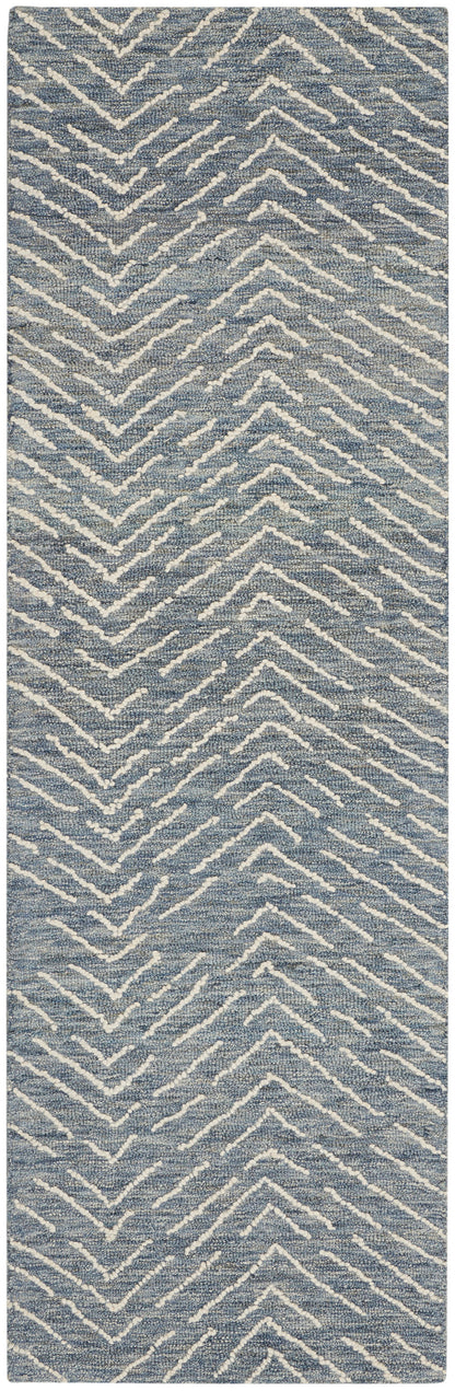 Blue textured rug runner with white chevron zigzag pattern.