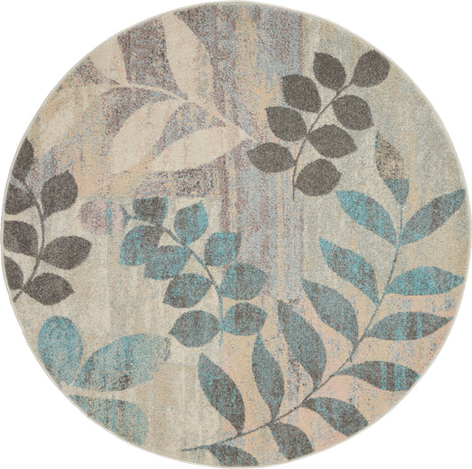 Round rug with beige background and teal, gray and blue leafy pattern; soft, textured surface.