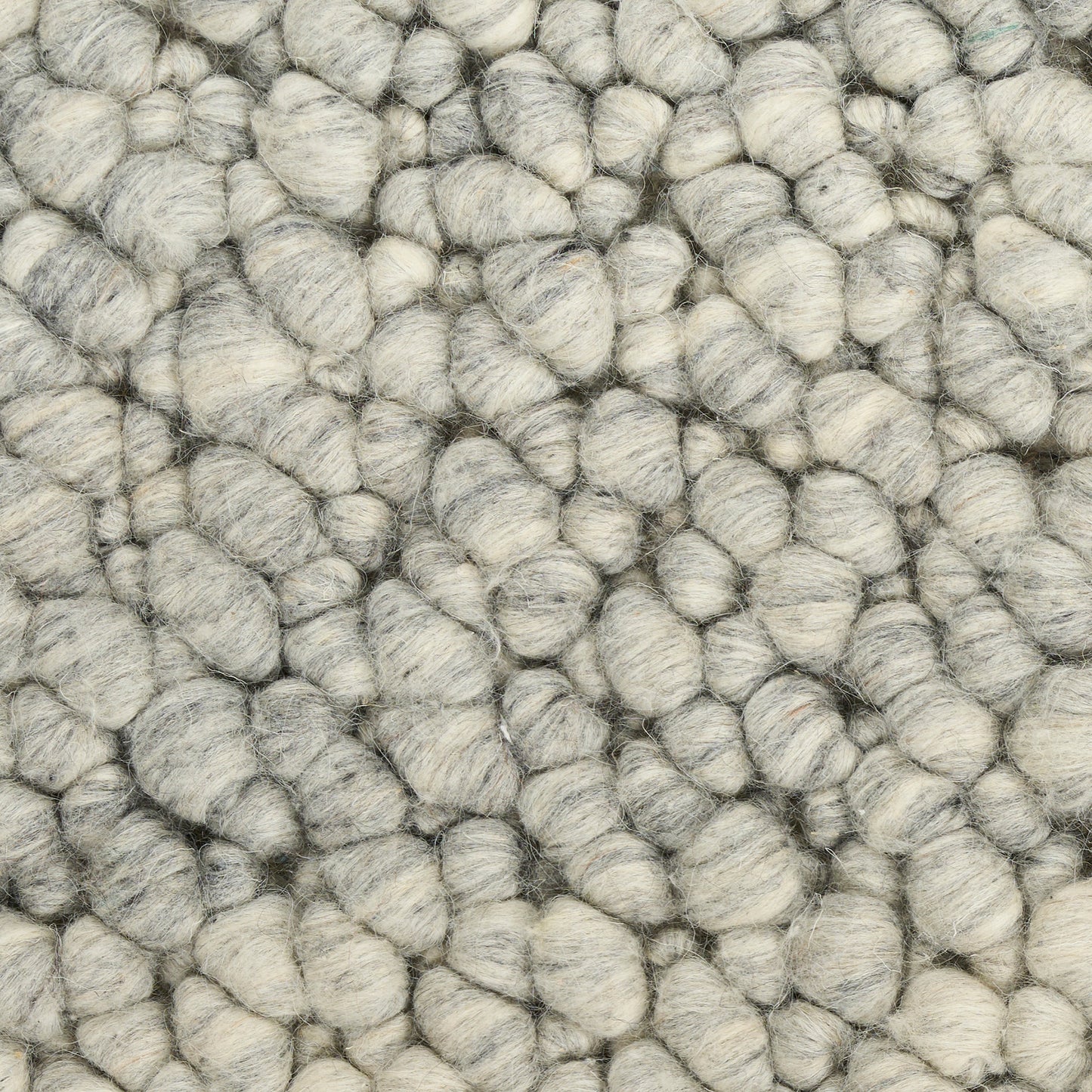Close-up of light gray boucle yarn with chunky rounded loops; plush, soft rug texture.
