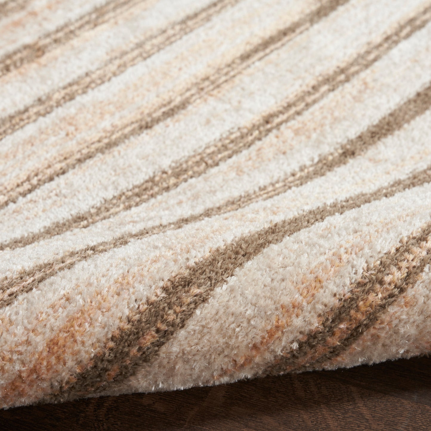 Beige and brown striped plush rug, close-up of soft textured pile with diagonal pattern.
