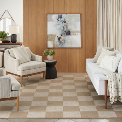 Mid-century beige living room with checkered rug, cream upholstered sofa and chairs, wood paneled wall, abstract art.