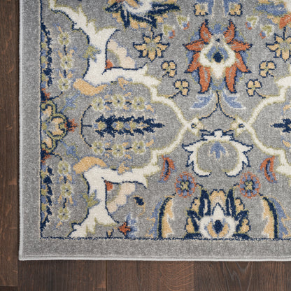 Gray Bohemian rug with blue & ivory & orange floral medallions and a light gray border on dark wood floor.