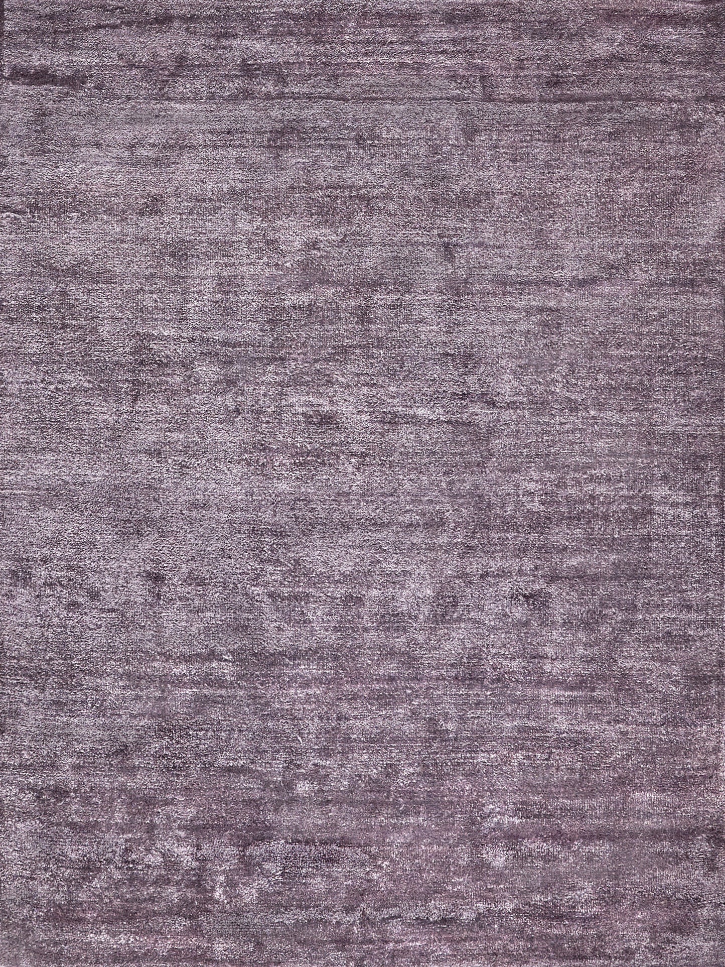 Muted purple-gray plush rug with distressed texture and rectangular shape.