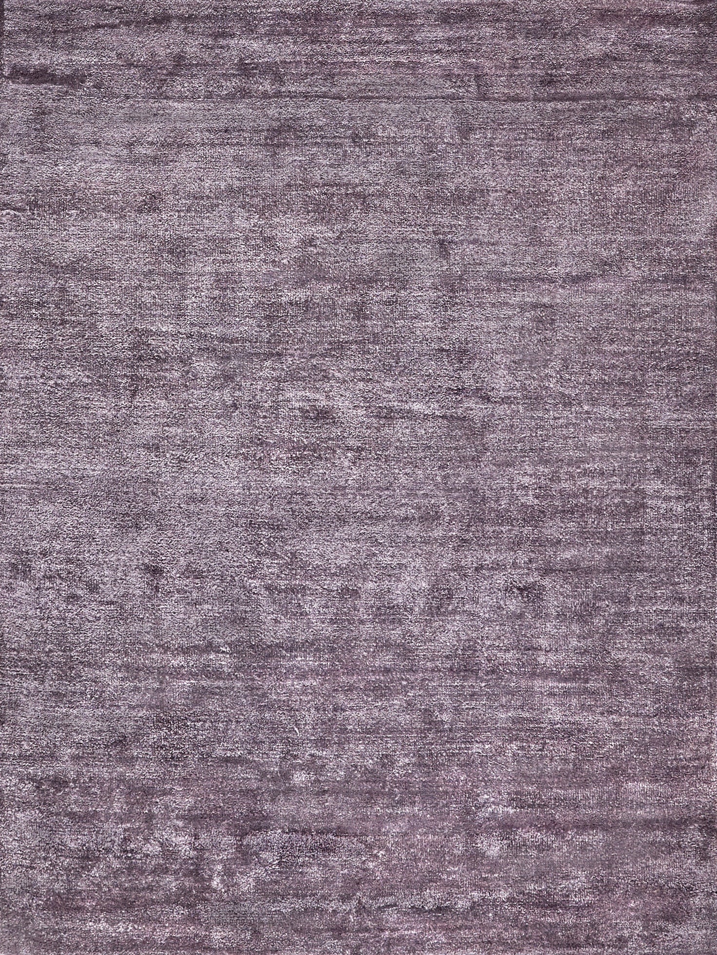 Muted purple-gray plush rug with distressed texture and rectangular shape.