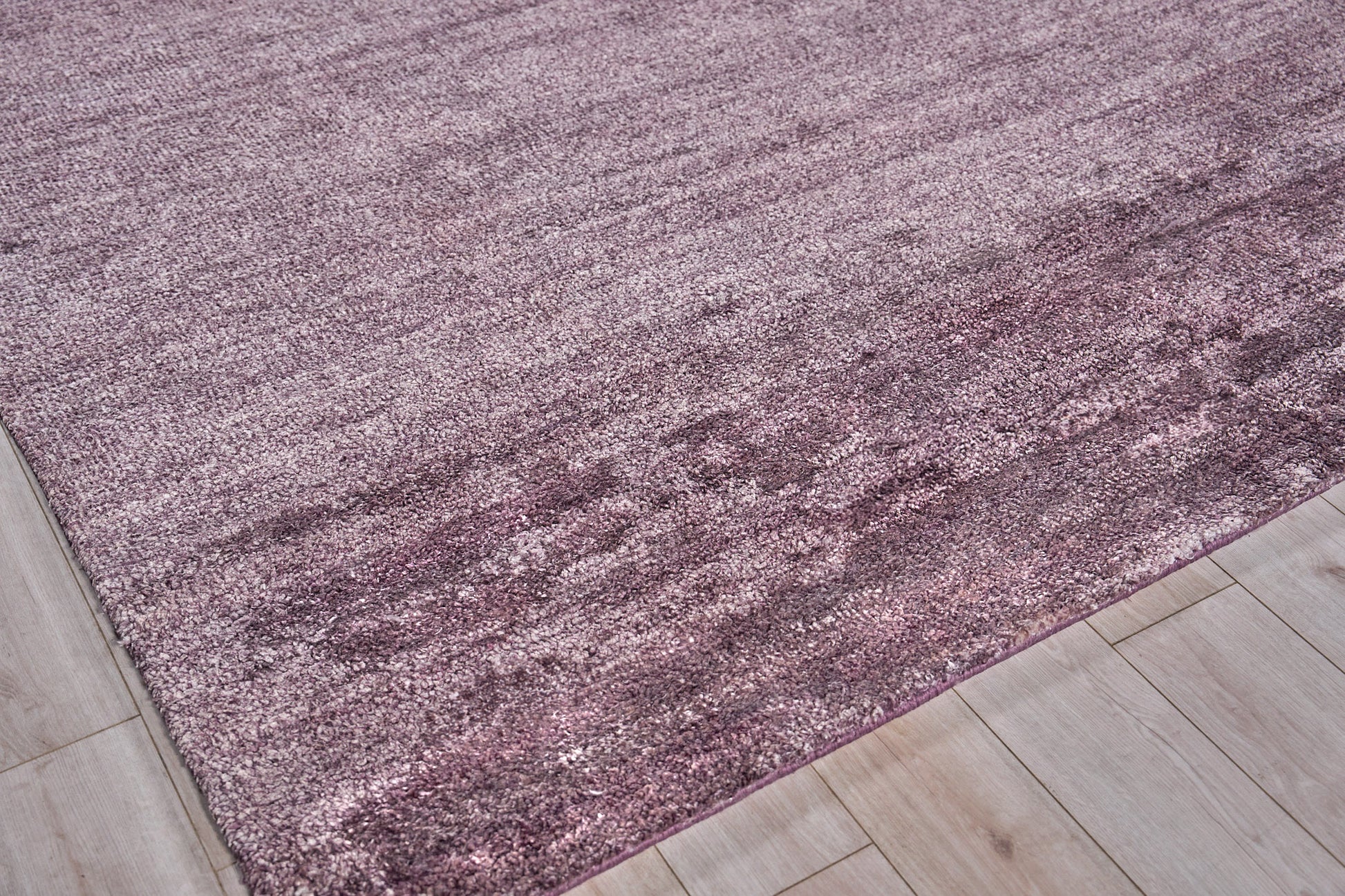 Dusty rose hand-knotted plush indoor rug on light wood floor.