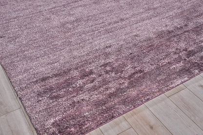 Dusty rose hand-knotted plush indoor rug on light wood floor.