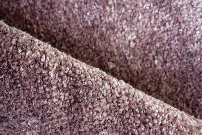 Close-up of soft mauve-brown plush rug with curly pile texture.