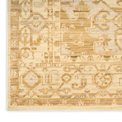 Corner view of a beige oriental rug with an intricate geometric and floral border in warm ivory and gold tones.