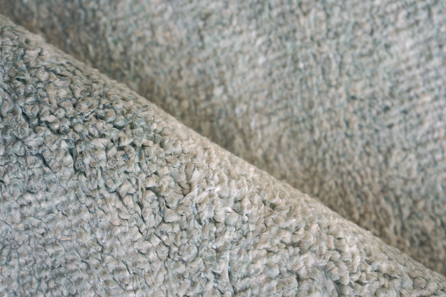 Close-up of light gray plush indoor hand-knotted rug with soft shag pile, 2' x 3'.
