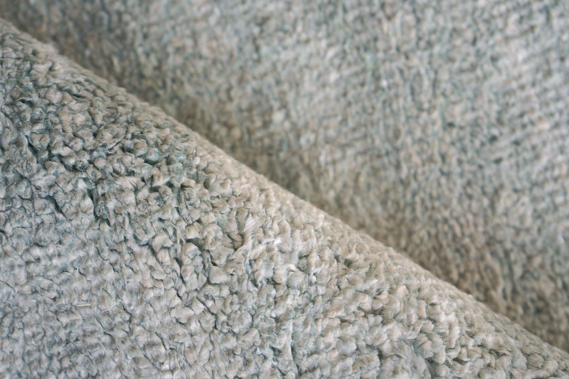 Close-up of light gray plush indoor hand-knotted rug with soft shag pile, 2' x 3'.